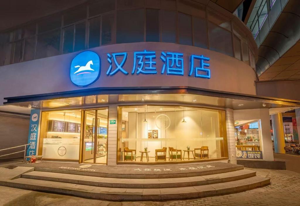 un magasin avec une enseigne sur le côté d'un bâtiment dans l'établissement Hanting Hotel Shanghai Jiaotong University Jiangchuan Road Subway Station 2, à Shanghai