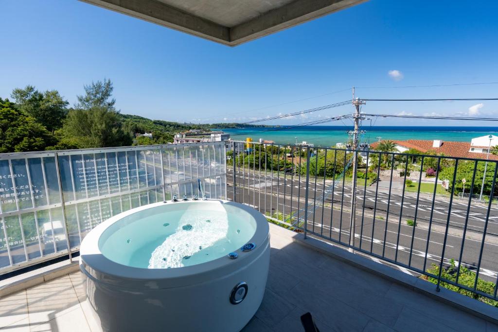 a bath tub on a balcony with a view of the ocean at Emerald Ocean Villa in Onna
