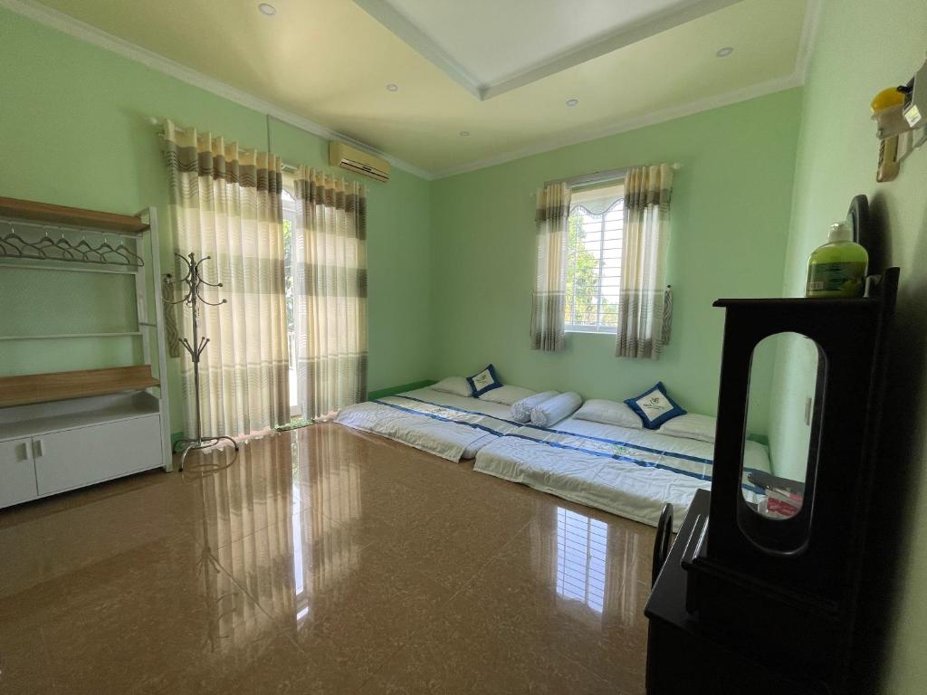 ein Zimmer mit zwei Betten in der Zimmerecke in der Unterkunft Như Ba Farmstay in Kon Rung (1)