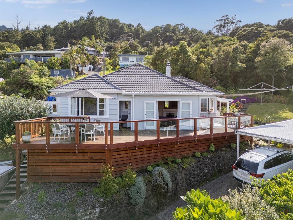 a house with a large deck with a car parked in front at Coro Harbour View - Coromandel Holiday Home in Coromandel Town