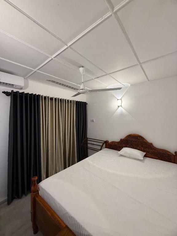 a bedroom with a bed and a ceiling fan at White place in Ahangama