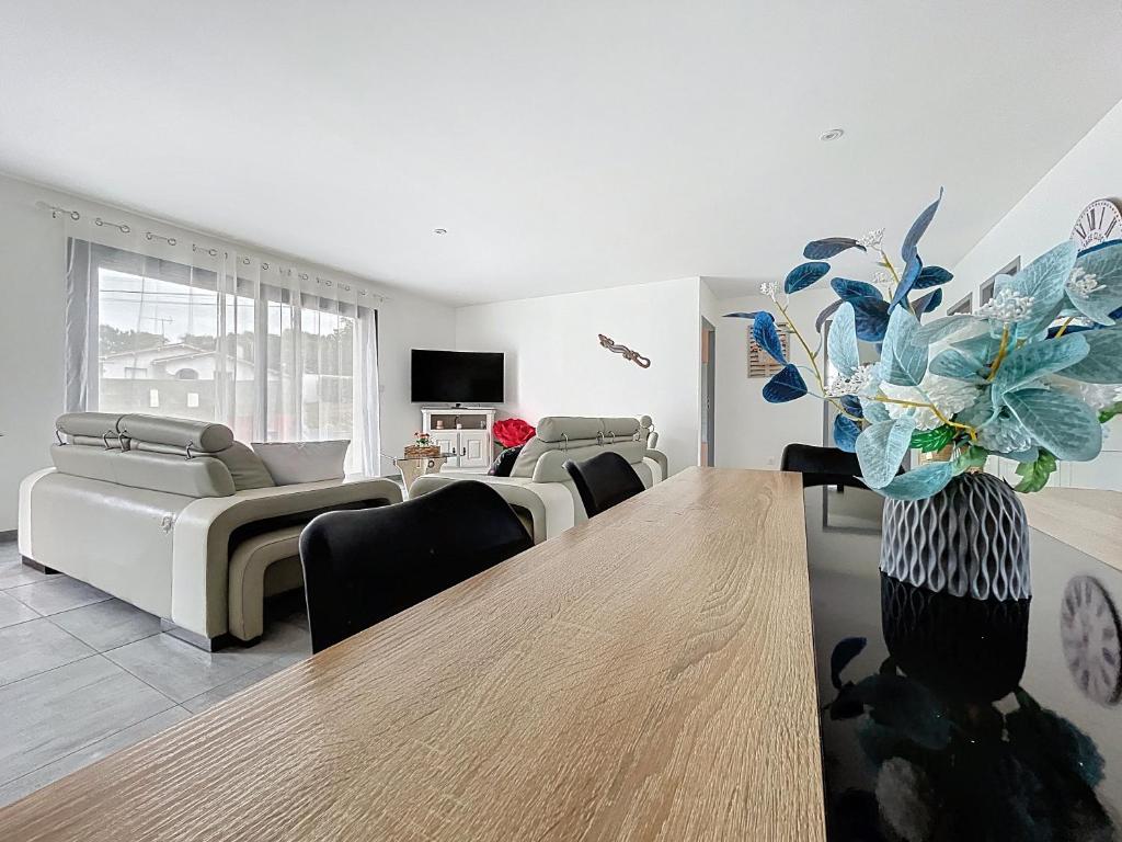 een woonkamer met een tafel en een bank bij Maison Lahourcade in Lahourcade