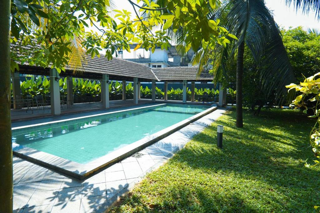 Private Pool Villa in Thodupuzha- Heliconia Inn في Thodupuzha: حوض سباحة في ساحة منزل