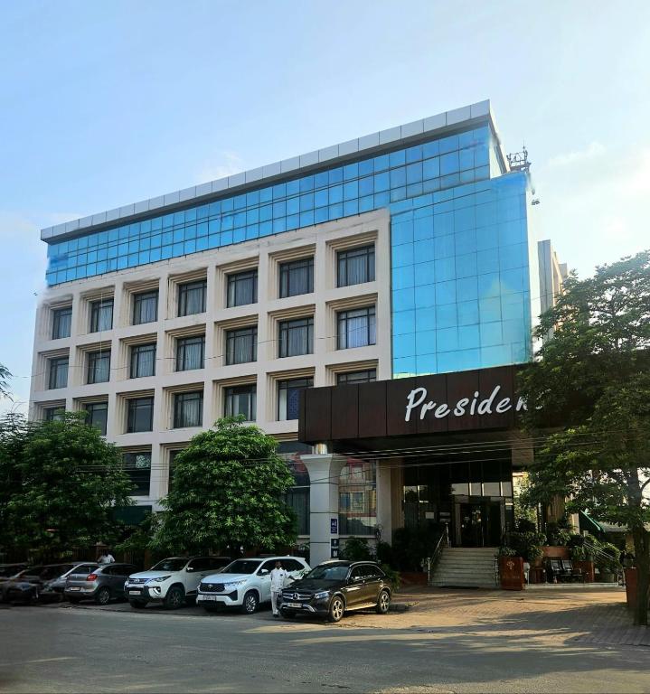 a large building with cars parked in front of it at Hotel President in Jalandhar