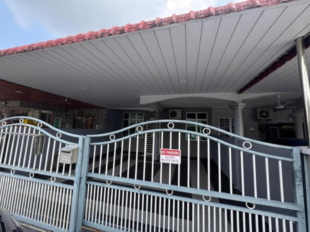 a white gate with a no trespassing sign in front of a house at D' Mutiara Homestay in Simpang Ampat