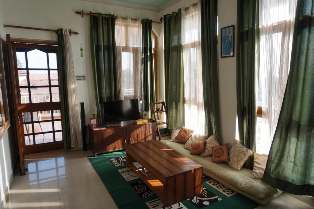 a living room with a couch and a tv at Guler House in Jāmb
