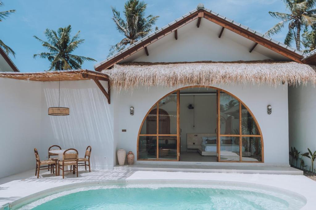 a villa with a swimming pool and a house at Lumora Boutique Villas in Gili Trawangan