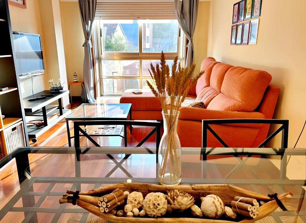 een woonkamer met een glazen tafel met een vaas bij Holibai, Chuliña, Vacaciones Familiares en Baiona, Espacio, Piscina y Playa a un Paseo in Baiona