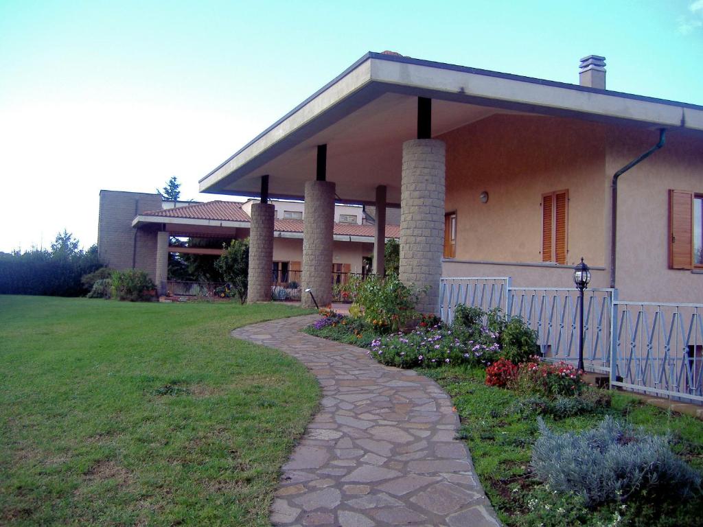a house with a walkway in front of a yard at Villa Chiara in Bracciano