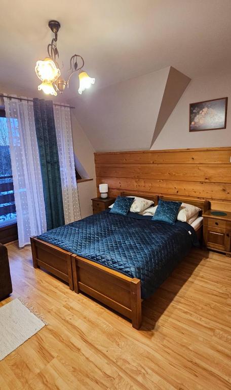 a bedroom with a large bed with a wooden headboard at Maria Chyc wynajem pokoi gościnnych in Zakopane