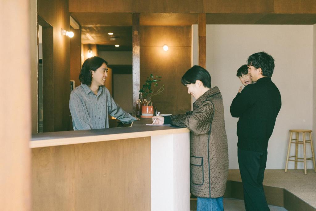 a group of people standing around a counter at ONYO Hotel and Lounge in Ueda