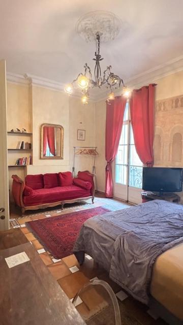 a bedroom with a bed and a couch and a tv at Bartissol et Maillol in Perpignan