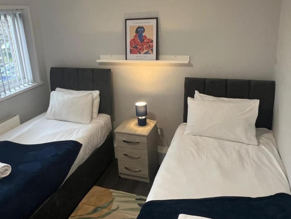 um quarto com duas camas e uma mesa de cabeceira em 8 person 4 bedroom 4en-suite Free Parking em Warwick