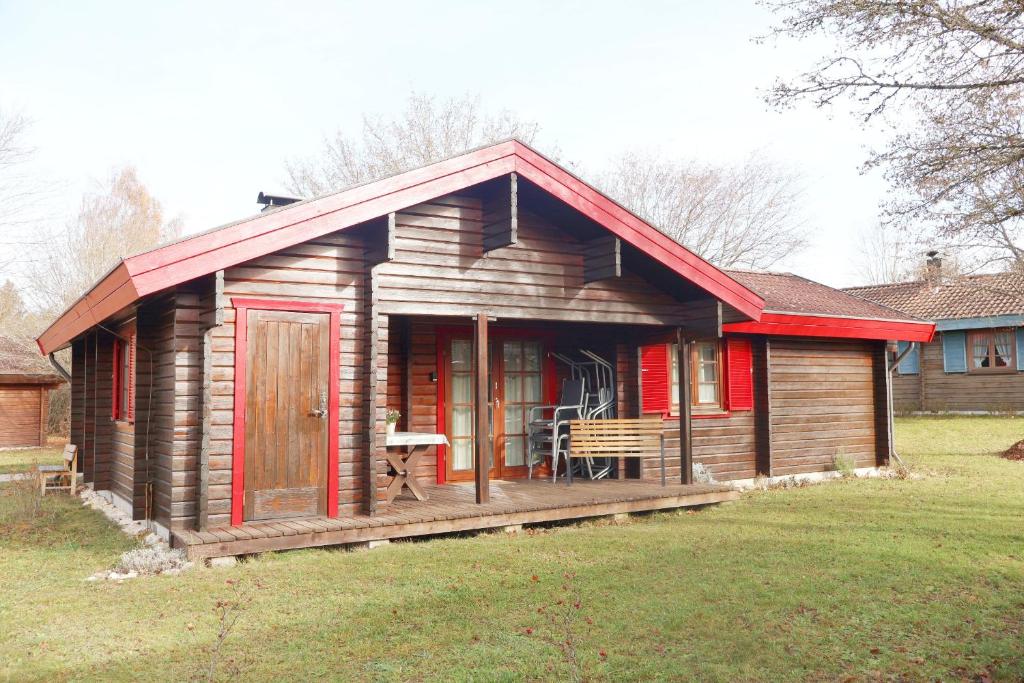 een klein houten huis met een rood dak bij Ferienhaus Neckar 70 in Hayingen