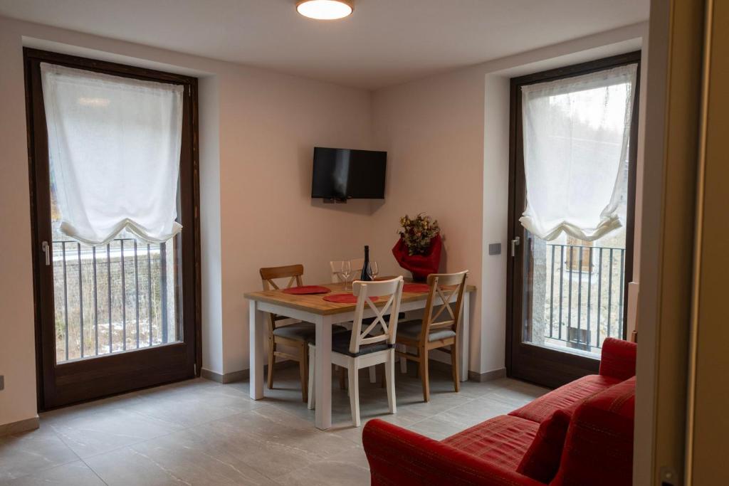 un soggiorno con un tavolo e un divano rosso di Casa da Normi a Valdisotto