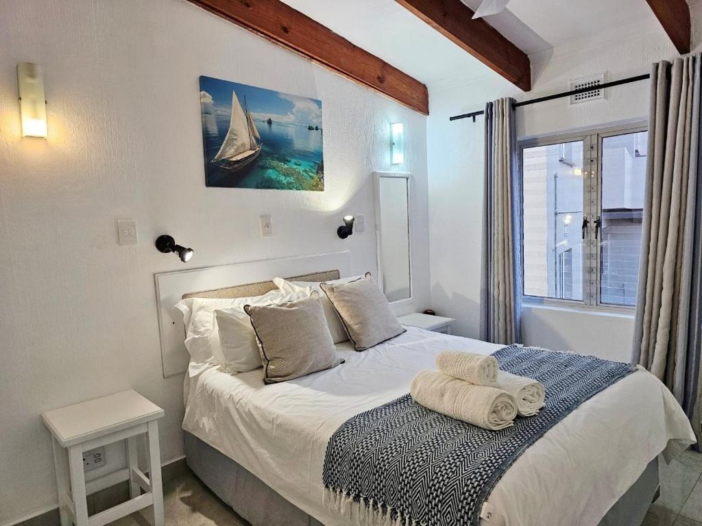 a bedroom with a bed with a towel on it at Chakas Rock Chalet 45 in Ballito