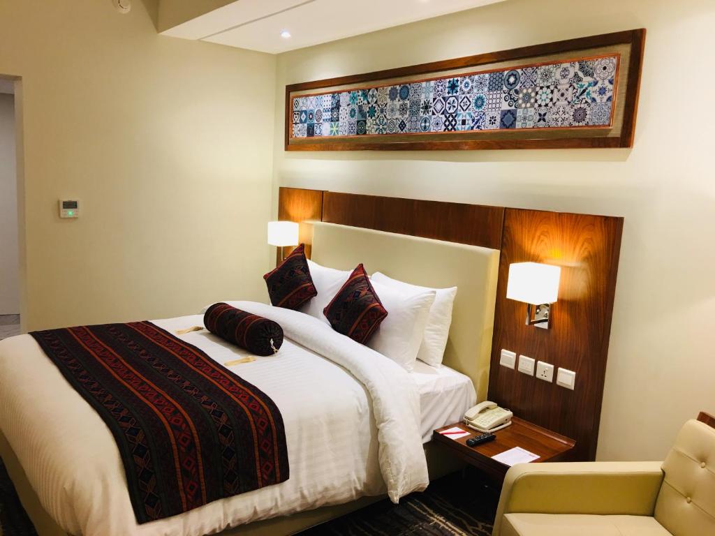 una habitación de hotel con una cama y una silla en Avari Xpress Multan, en Multán