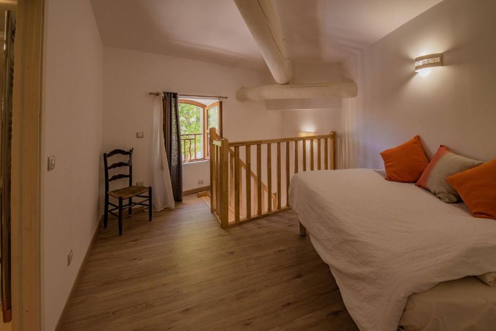 a bedroom with a bed and a wooden floor at Spacieux Duplex - Lumineux et Calme - Alpilles in Eyguières