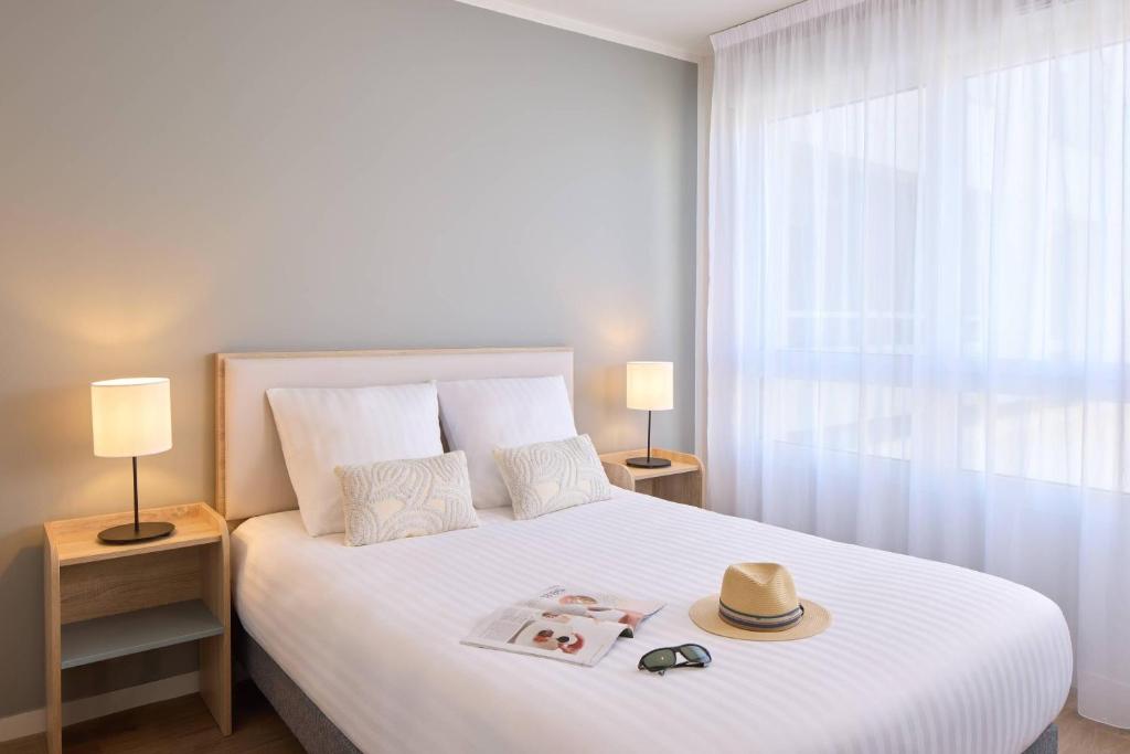 Un dormitorio con una cama con un sombrero encima. en Quality Suites Saumur, en Saumur