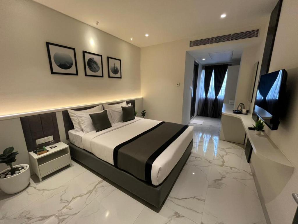 a bedroom with a large bed and a television at S by Z Hotels, HSR in Bengaluru