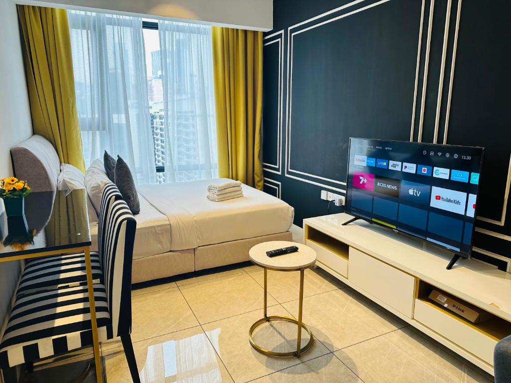 a small bedroom with a bed and a television at Bukit Bintang Suites KL in Kuala Lumpur