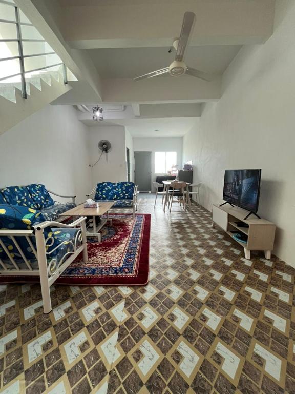 a living room with two beds and a tv at Qaseh homestay in Papar