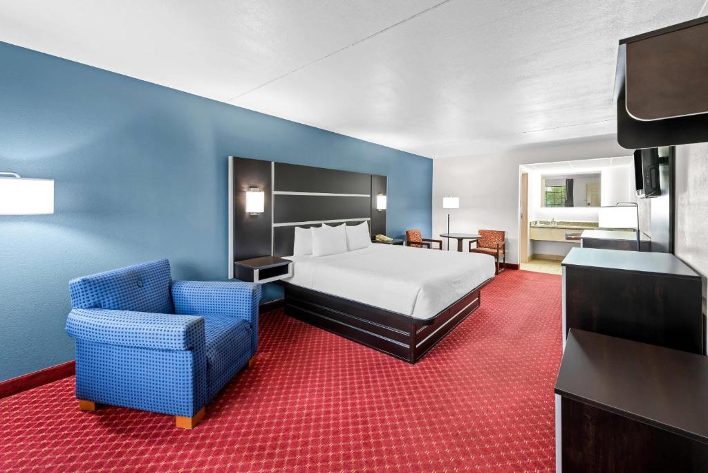 una habitación de hotel con una cama y una silla en Clarion Inn Branson, en Branson