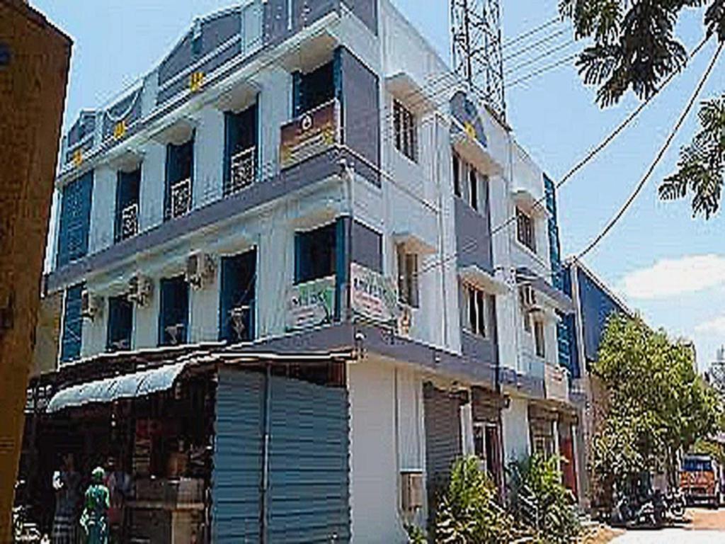 a large building with a garage in front of it at Hotel O 81239 Shri Vinayaka Inn Rooms in Tiruchchirāppalli