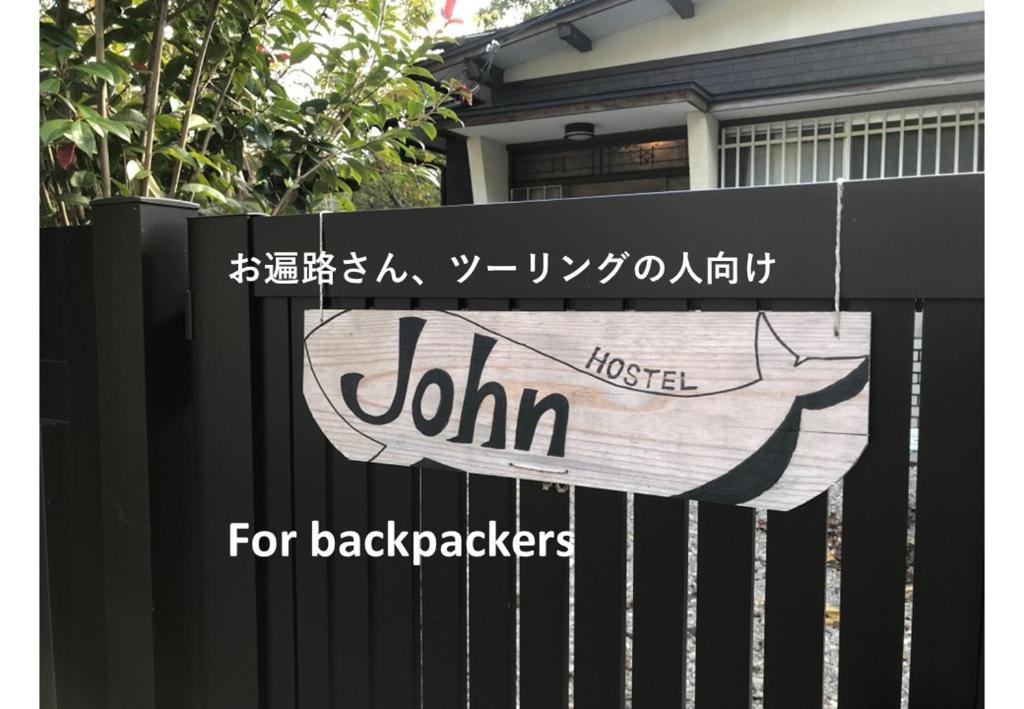 a sign on the gate of a black fence at Hostel John Mang ゲストハウス ジョン in Tosa