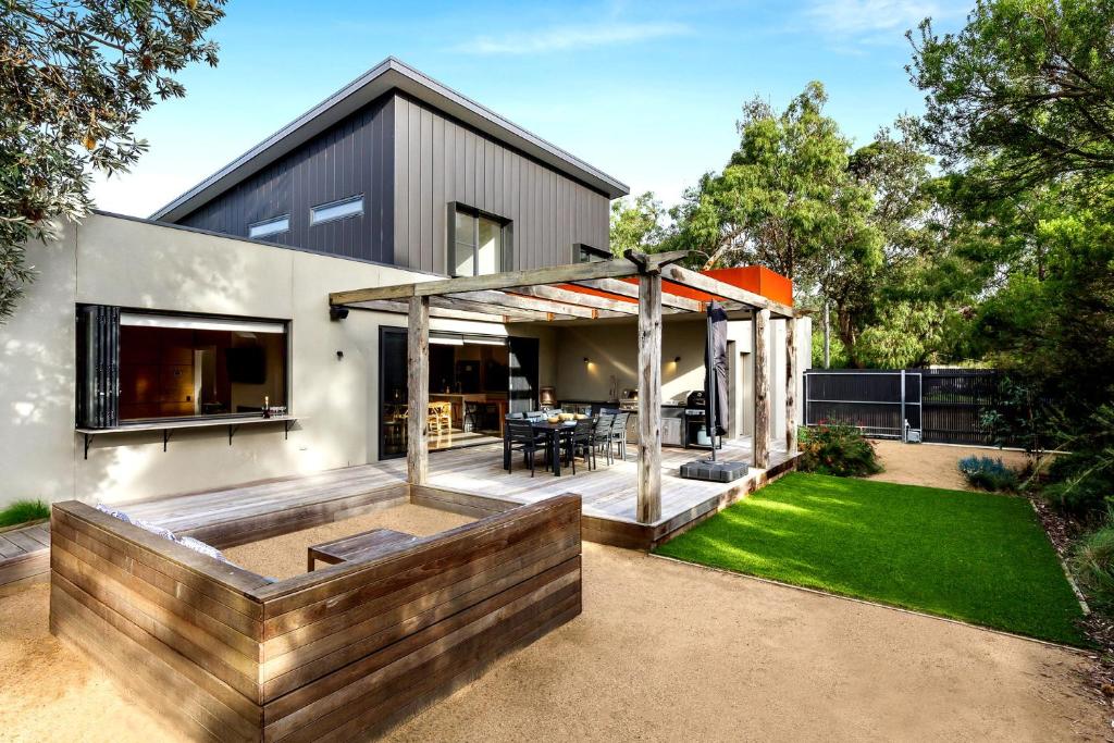 a modern house with a deck and a backyard at Bali Hi Walk to Beach in Balnarring Beach