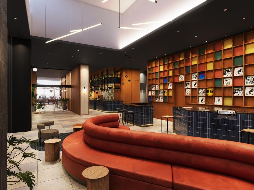 Un vestíbulo con un gran sofá de cuero en una biblioteca. en Tokyu Stay Hakata, en Fukuoka