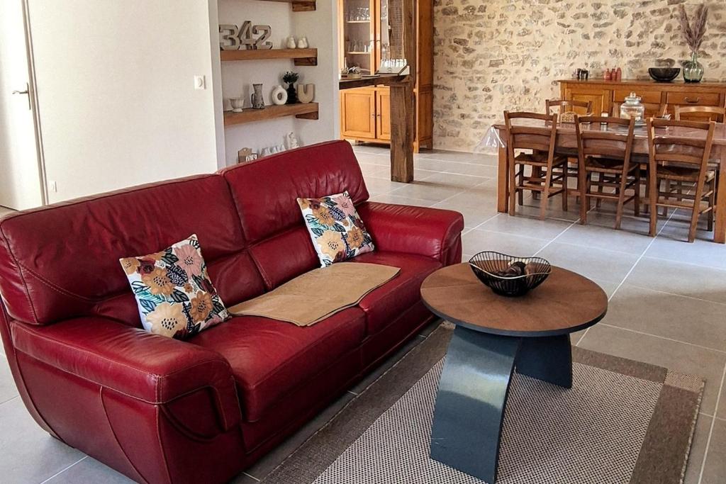a red couch in a living room with a table at Gîte Le repos du voyageur in Mary