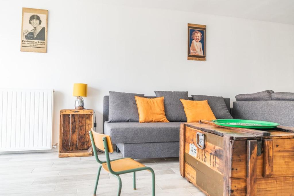 ein Wohnzimmer mit einer Couch und einem Tisch und einem Stuhl in der Unterkunft Appartement avec Jardin in Gerzat