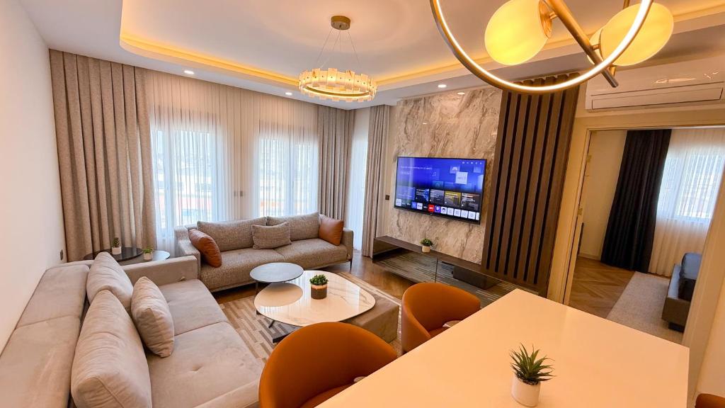a living room with a couch and a tv at Hiper Suites Residance in Antalya