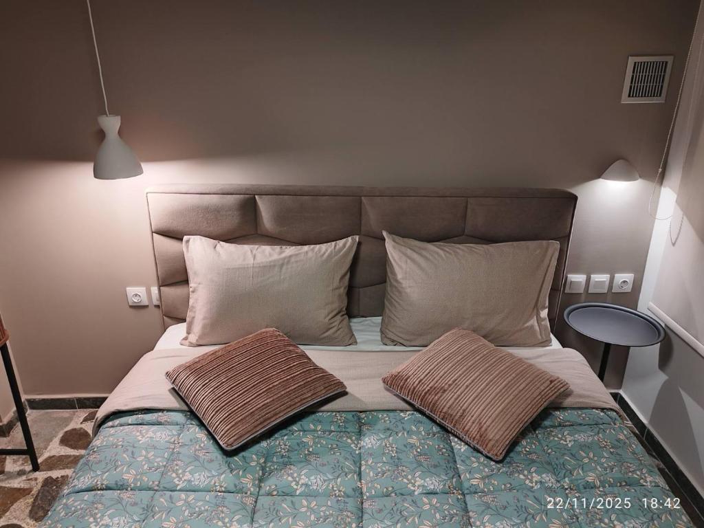 un letto con due cuscini sopra in una camera da letto di Feggaropetra a Kalívia