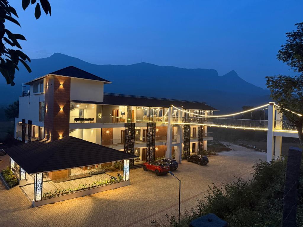 een uitzicht op een gebouw met een brug 's nachts bij Veera Resort in Attigundi