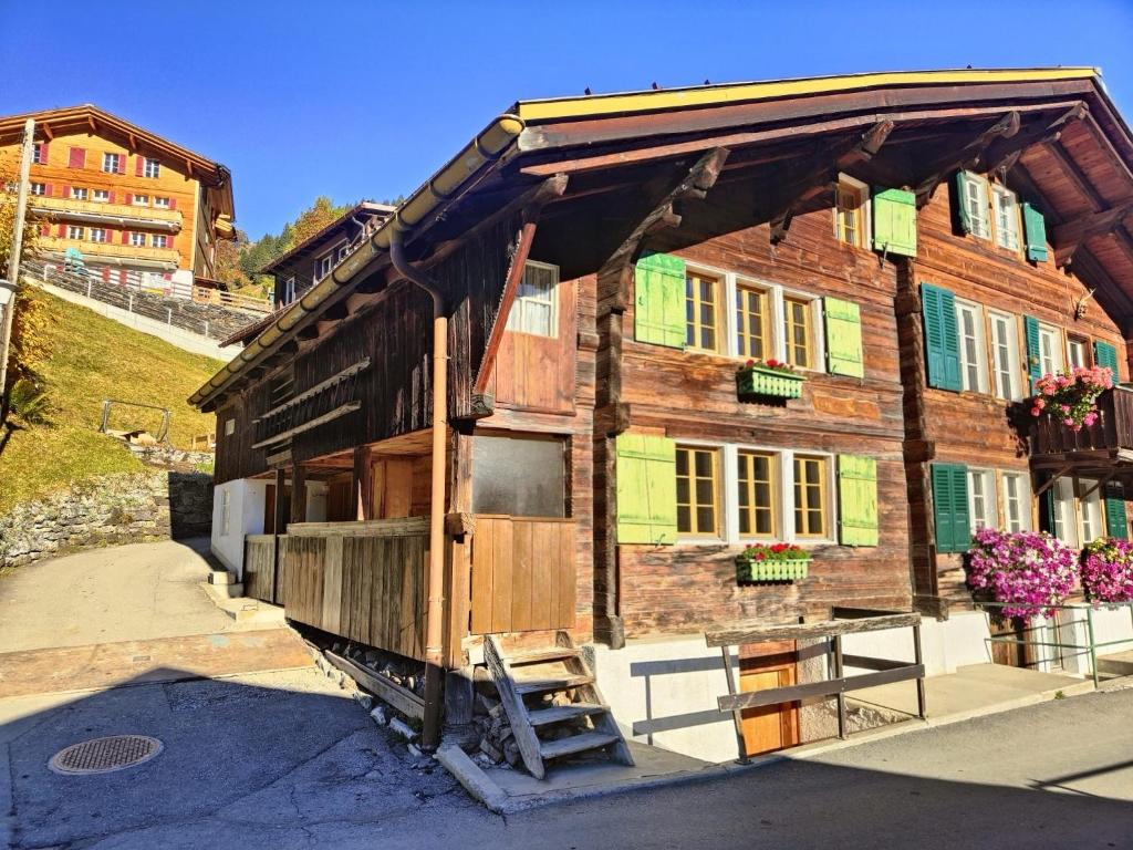 a wooden house with a ladder in front of it at Renovated traditional chalet in car-free Mürren in Mürren