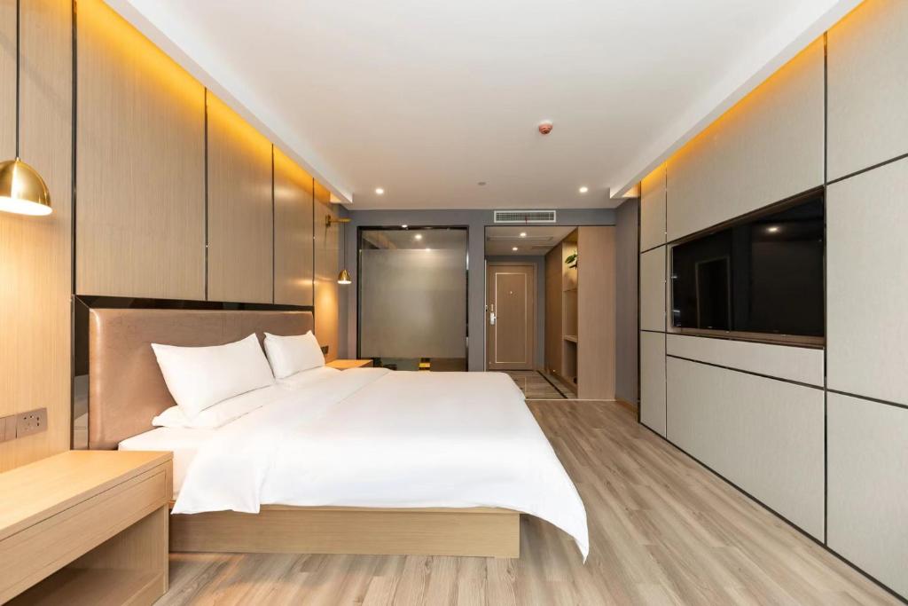 een slaapkamer met een groot bed en een flatscreen-tv bij Starway Hotel Shanghai Hongqiao National Exhibition and Convention Center Beiqing Road in Shanghai