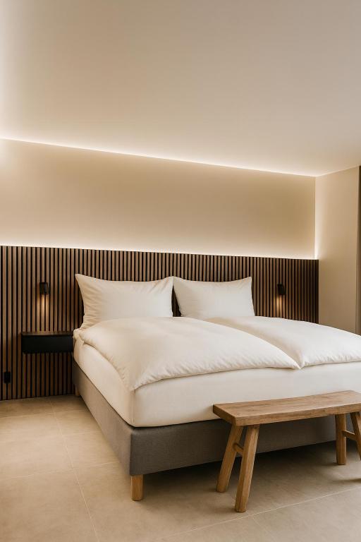 a bedroom with a large bed and a wooden bench at Escala in Fully
