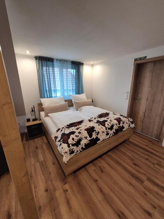 a large bed in a bedroom with a wooden floor at FeWo Zenk Stublang in Bad Staffelstein