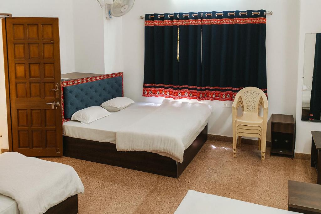 a bedroom with two beds and a window at Stay Guru Resort Farm Villa in Bhuj