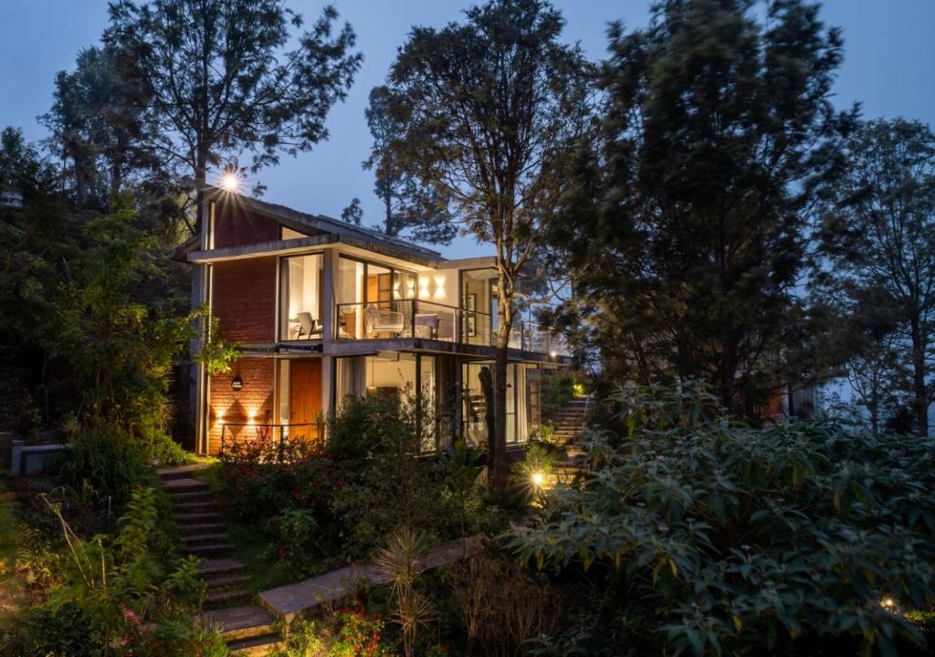 a house in the woods at night at LohonoStays Amani Villa 10A in Coonoor