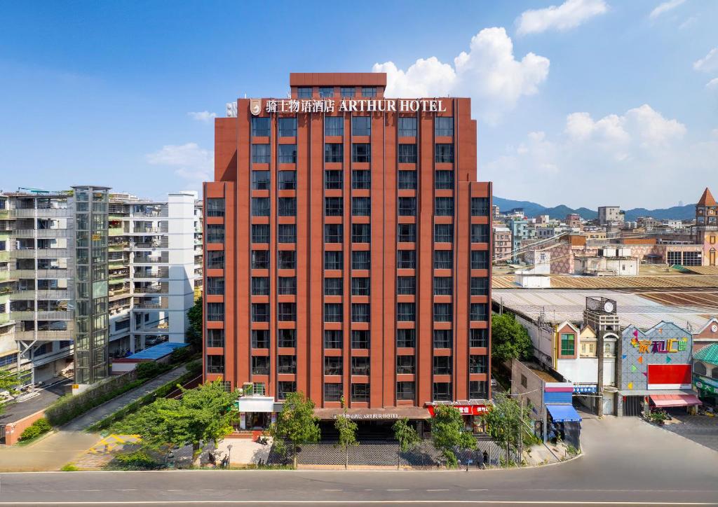 a red brick building with a hotel sign on it at Arthur Hotel Baiyun Station Xinshixu Subway Station Guangzhou in Guangzhou