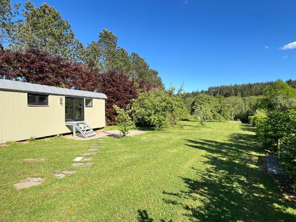 a garden with a small shed and a yard at Pine Tree Tiny cottage in Rochefort