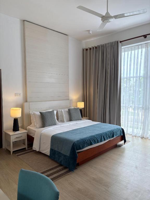 a bedroom with a large bed and a blue chair at Villa Talay - 5 Bedroom Beachfront Villa in Talalla South