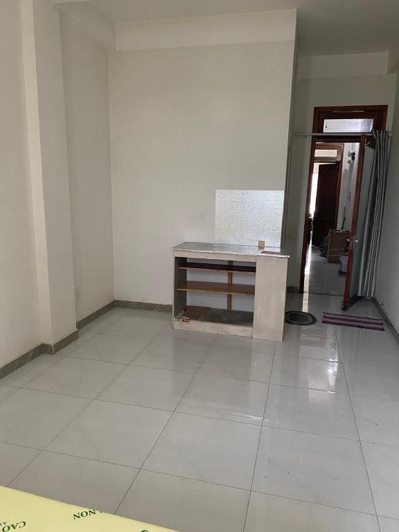 een lege kamer met een tafel op de vloer bij Không có tên in Ho Chi Minh-stad