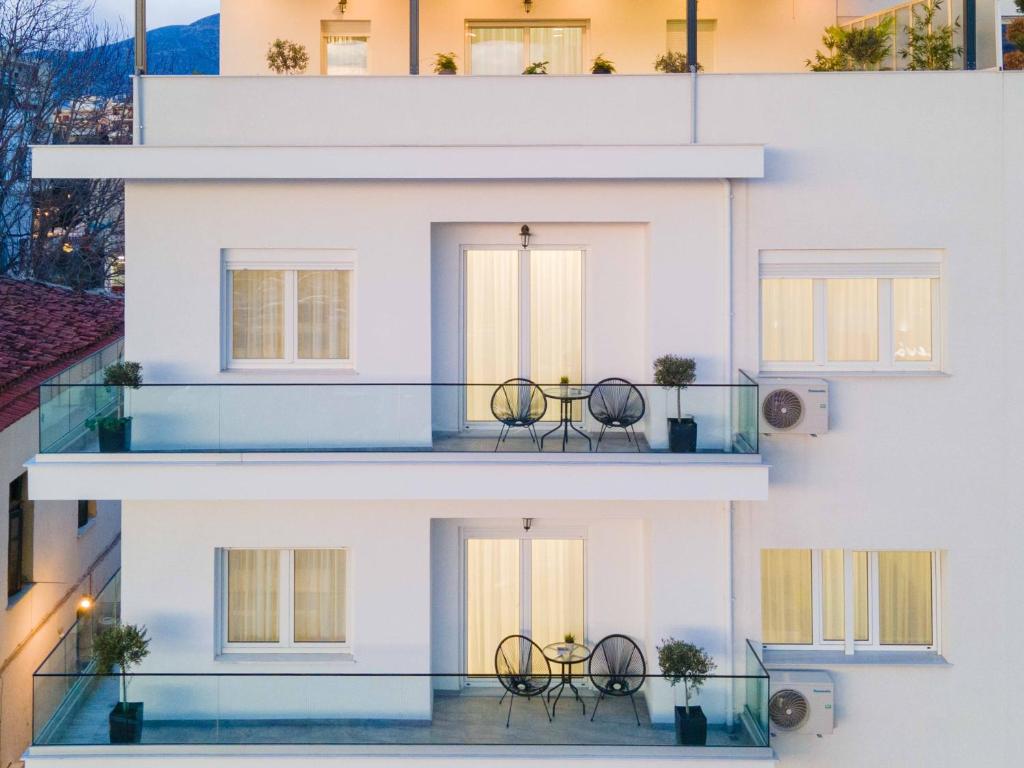 um edifício com duas cadeiras na varanda em Arcade Apartments 1st floor em Volos