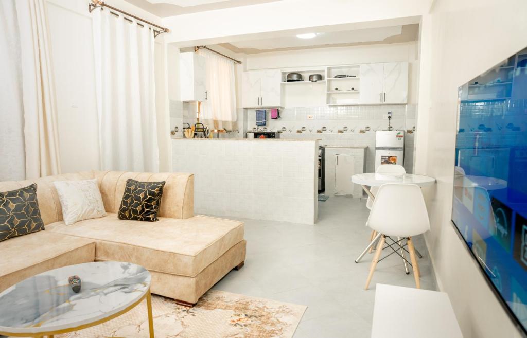 un soggiorno con divano e cucina di Amno Elite Suites a Naivasha