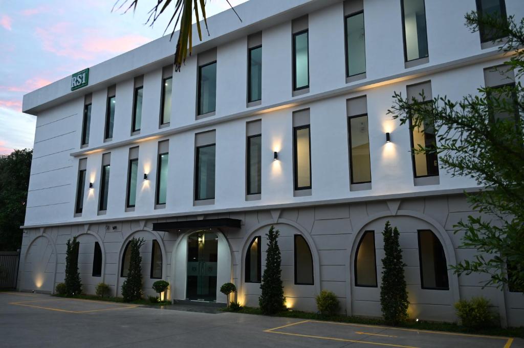 a white building with a lot of windows at RS1 Hotel in Ban Pho Touane