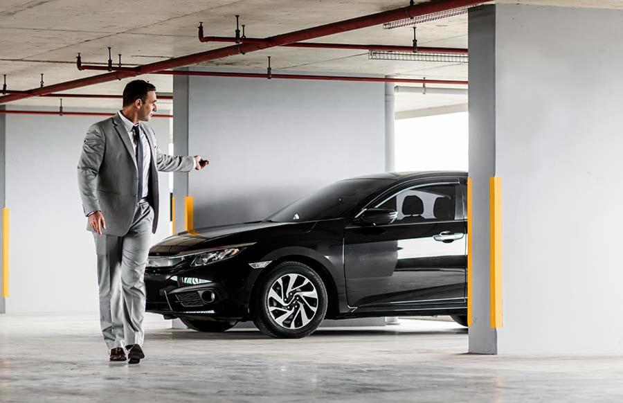 Een man in een pak die naast een zwarte auto staat. bij Centro & Mare 2 Essential - Rooms - Garage in Termoli